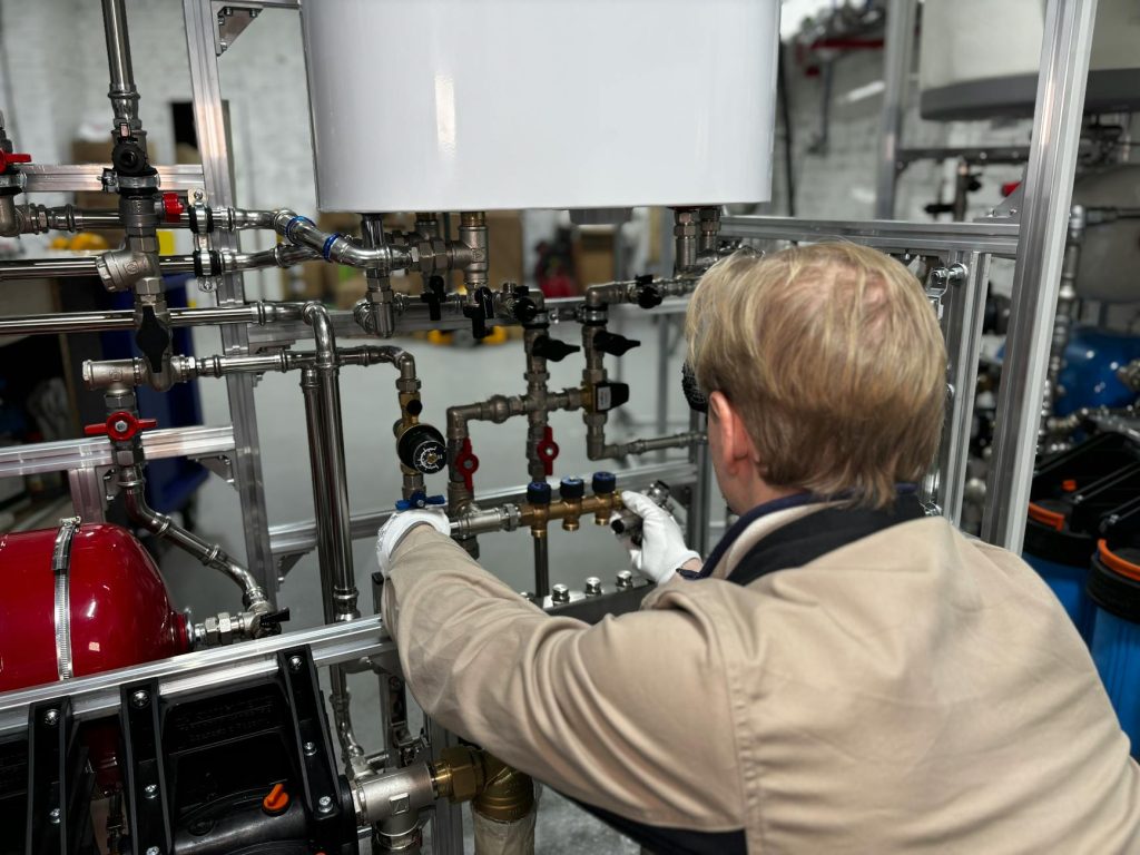 what size hot water system do I need - plumber fitting water supply pipes at Gold Coast home